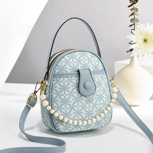 Light blue mini handbag with pearl chain and leather shoulder strap on a white surface