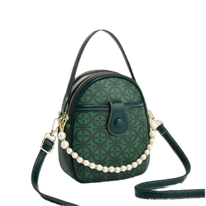 Dark green mini leather crossbody bag with circular pattern and pearl chain detail