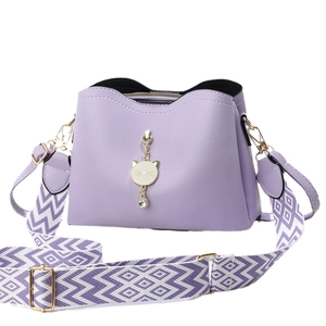 Lavender faux leather crossbody bag with cat charm and geometric patterned strap
