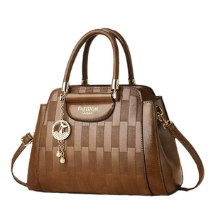Brown faux leather bucket bag with woven texture, dual handles and golden fish charm