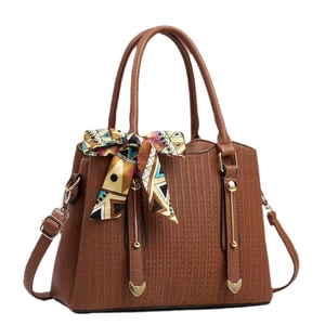 Elegant brown leather tote bag with colorful silk scarf and golden heart pendants