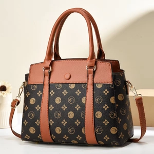 Détail d'un sac à main noir et marron avec motifs de tête de cheval dorés et fleurs
