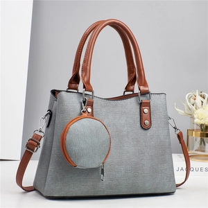 Sac cabas gris texturé avec lanières en cuir marron et pendentif porte-monnaie rond