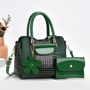 Detail of dark green crocodile texture handbag set with shiny patent leather finish