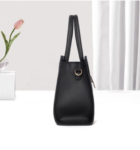 Detail view of the black snake-texture handbag featuring golden D-ring metal connectors