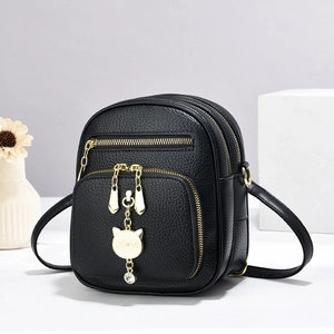 Mini zaino nero in ecopelle e borsa a tracolla con ciondolo a forma di gatto dorato