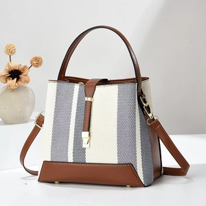 Blue and white striped woven bucket bag with brown leather trim and gold hardware