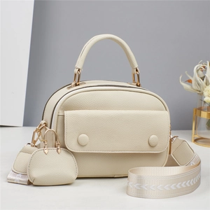 Minimalist beige pebble leather handbag with woven shoulder strap and charm pendant