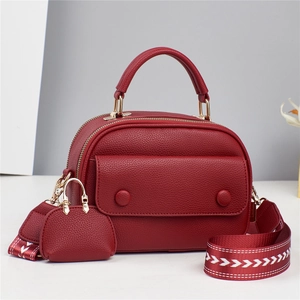 Minimalist burgundy textured handbag with top handle and wide woven shoulder strap