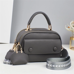 Detail of dark grey litchi grain leather crossbody bag with jacquard woven strap