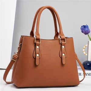 Macro detail of tan lychee pattern faux leather handbag with golden metal rivets