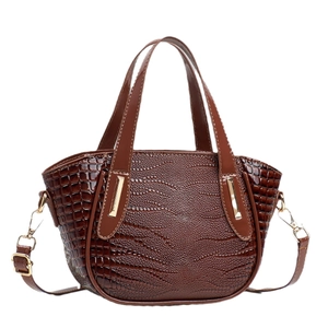 Dark brown crocodile embossed handbag with gold hardware and adjustable strap