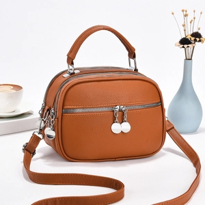 Detail of brown multi-zip handbag showing lychee texture and silver hardware accents