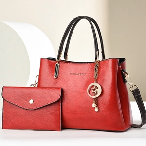 Red embossed tote bag and clutch set with gold hardware and pearl star charm details