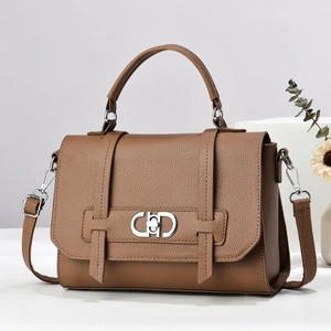 Detail of brown litchi grain leather handbag with silver double-ring metal buckle lock
