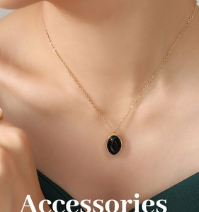 Gros plan d'un collier vintage en or avec pendentif ovale noir porté au cou