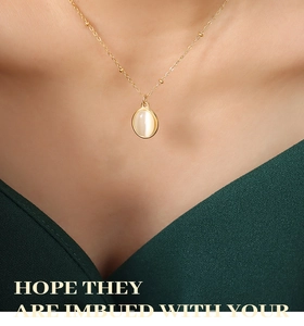 Détail du collier à billes dorées avec pendentif opale ovale porté par un mannequin