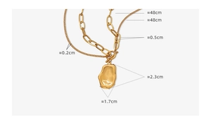 Detail view of double-layered gold necklace with irregular pendant and OT buckle