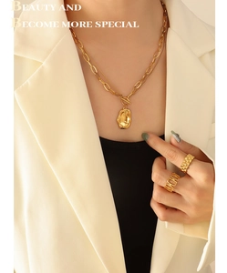 Detail of gold-plated double-layer necklace with irregular lava pendant and OT toggle clasp