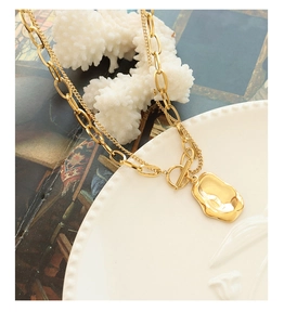Detail of double-layer gold plated titanium steel necklace with irregular pendant and OT buckle