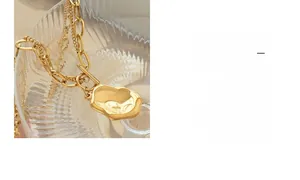 Close-up of double-layer gold plated necklace with irregular organic pendant and chain texture