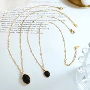 Collier vintage en titane plaqué or 18K avec deux pendentifs ovales en œil de chat noir