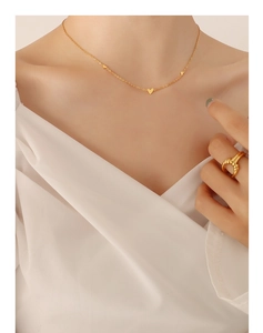 Close-up of minimalist heart pendant necklace in gold-plated finish on a model's neck
