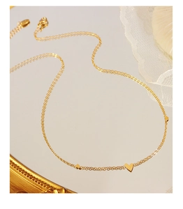 Detail of a minimalist gold heart pendant necklace with adjustable chain and lobster clasp