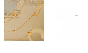 Detail shot of dainty gold heart pendants on a slim chain over vintage book pages
