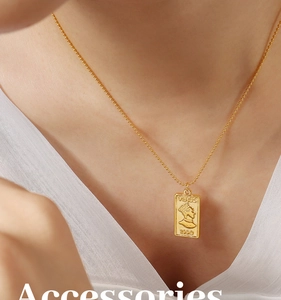 Macro detail of a gold-plated Venus portrait pendant on a vintage bead chain necklace