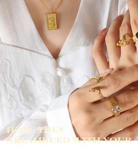 Detailed close-up of vintage gold portrait pendant necklace and assorted gemstone rings