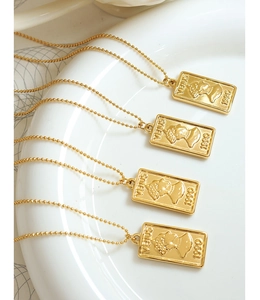 Detail of gold-plated portrait pendant necklaces hanging on a white ceramic plate