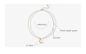 Macro shot of freshwater pearl necklace with 18K gold crescent moon pendant detail