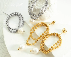 Detailed close-up of double-layered pearl tassel earrings in gold and silver finishes