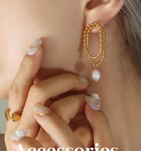 Detail of vintage gold double-hoop earrings with elegant freshwater pearl pendants