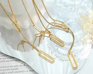 Détail d'un collier chaîne en or avec maillons rectangulaires sur un miroir