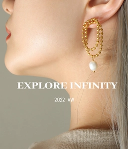 Close-up of elegant gold beaded double hoop earrings with a teardrop freshwater pearl on model
