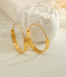 Makro-Detail geometrischer Gold-Creolen mit polierter 18k Goldbeschichtung Finish