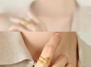 Close-up of golden double-layer open ring featuring horseshoe and circle elements on model