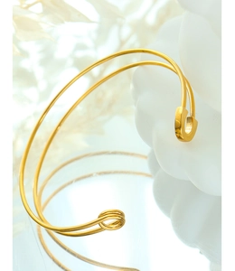 Detailed close-up of a golden safety pin bracelet with a minimalist double-line design