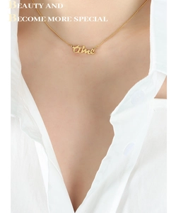 Gros plan d'un collier double épaisseur en acier titane plaqué or 18 carats avec pendentif