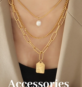 Detailed view of triple-layered gold necklaces with pearl and portrait coin pendants