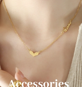 Close-up of a gold heart pendant necklace with Love engraving and side lettering