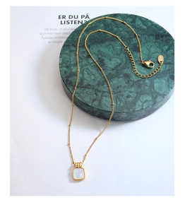 Detail of square shell pendant on 18K gold plated bead chain with adjustable lobster clasp