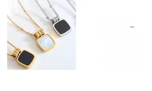 Detail of square gold pendants with black acrylic and white shell inlay on beaded chains