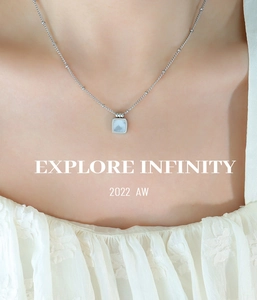 Close-up of minimalist titanium steel necklace with square grey shell inlay on skin
