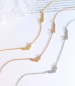 Detailed shot of gold and silver Love heart pendants on delicate titanium necklaces