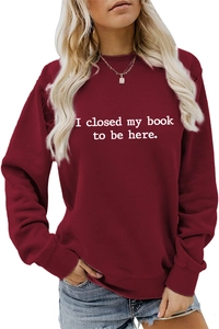 Detail of burgundy crewneck sweatshirt with I closed my book to be here text print