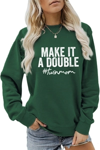 Close-up of 'MAKE IT A DOUBLE #twinmom' white print on a dark green crewneck sweatshirt