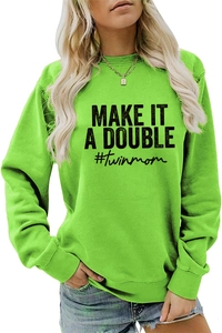 Close-up of vibrant green sweatshirt with black MAKE IT A DOUBLE slogan and ribbed cuffs